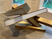 Front perspective showing intersecting rectangular light bars and mounting base on tabletop.