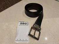 Rolled belt with buckle next to MaxSold tag