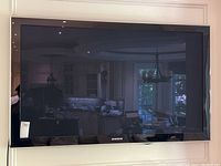 Front view of mounted Samsung TV showing bezel, screen and overall condition