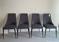 Front view of all four chairs in a row against wall