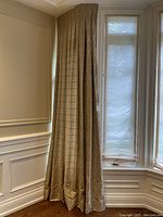 Single curtain panel hanging in a corner by a window revealing full length.