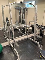 Front view of full squat rack showing frame, pull-up bar and barbell catches