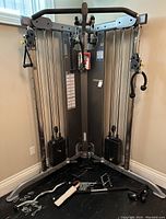 Front view of the cable machine and loose attachments on floor