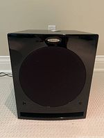 Front view showing circular speaker grille and front bass port