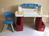 Step 2 kids art and school desk with blue and beige chair, front view showing storage compartments and work surface.