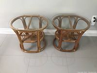 Pair of bamboo end tables with glass tops, front angle view showing frames and glass surfaces.