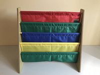 Front view of the child's book holder with five colorful fabric pockets in red, green, blue, yellow, and green.