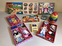 Full shot of the set showing all included items on display, including puzzles, magnetic dolls, stacking egg toy, and card games.
