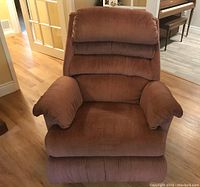 Front view of the brown fabric rocker recliner chair showing cushioned backrest and armrests.