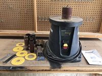 Front view of Mastercraft oscillating sander on workbench with sanding drums, discs, wrenches, and manual.
