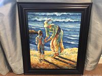Photo of the full framed painting showing the lady and child on the beach with ocean waves.