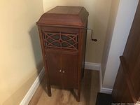 Closed wooden console showing ornate fretwork grille and lower storage doors