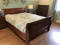 Full assembled bed frame showing headboard, footboard, side rails and box spring under bedding