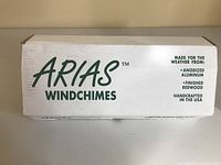 Box for Arias Wind Chimes showing the brand and materials used: anodized aluminum and finished redwood. Handcrafted in USA.
