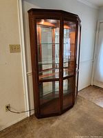 Full view of freestanding wood display cabinet with curved front