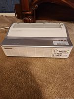 Full view of Oreck XL Professional Air Purifier on carpet with front vents and controls visible.