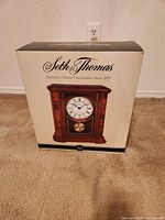 Front and sides of original retail box for Seth Thomas mantel clock showing image of clock and branding
