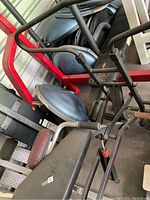 Photo showing the padded seat, handlebars, and part of the frame of the exercise machine.