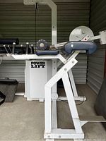Side view of white steel frame Power Lift reverse hyper machine with blue padding and hand grips.