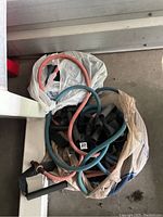 Photo shows a bundle of three coiled resistance bands of teal, pink, and black colors. Two bands have black foam handles. Bands in a plastic bag.