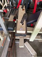 Calf extension machine with visible rust on handle mounts and footrest, navy blue seat and back.