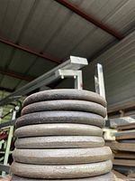 Stack of eight round 10 lb metal weight plates with surface rust and dirt