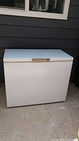 Front view of white Woods brand chest freezer, showing clean rectangular body and control panel on lid edge
