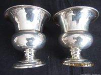 Pair of Birks sterling silver serving pieces with rounded urn shape and detailed rim, photographed front view.