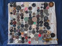 Full view of fabric panel with multiple rows of vintage and antique buttons in various colors, sizes, and styles.