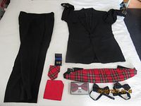 Full layout of tuxedo jacket, pants, and accessories displayed on a bed.