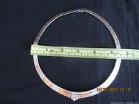 The necklace laid flat with a measuring tape showing approximately 15 inches in length.