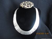 Full view of the sterling silver necklace displayed on a black velvet bust showing the broad flat link design.
