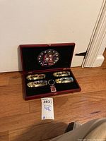 Open display box showing four painted Civil War themed pocket switchblade knives and a keychain inside with black velvet lining and Civil War emblem on lid