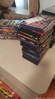 Photo showing several stacks of DVDs, mostly WWE wrestling event titles, with some other movie DVDs in the background.