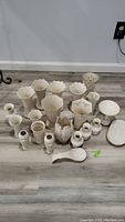 Full lot of Lenox porcelain items arranged on floor showing vases, small dishes and serving pieces.