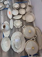 Overview photo of the Lenox servingware laid out on floor, showing a variety of pieces including covered dishes, bowls, platters, pitcher, and trays.