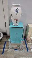 Full view of ceramic floral vase on Tiffany & Co. box with both crystal candlesticks in front.