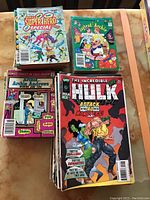 Photo showing stack of vintage Archie comics and an Incredible Hulk comic with superhero theme, all with worn edges.