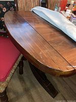 Photo of wooden dining table surface showing wear and finish marks