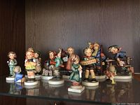 Group of Hummel figurines displayed on shelf