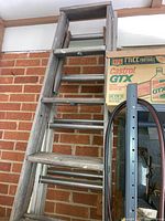 8-foot step ladder, aluminum construction shown against a brick wall.