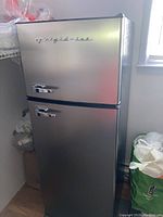 Full view of the Frigidaire refrigerator showing stainless steel finish and two doors with chrome handles
