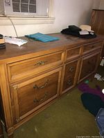Side view of the dresser showing drawer design and handle style with visible surface wear.
