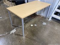 Side angle view of rectangular table showing wood surface and metal legs.