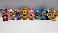 Front row view of 9 Cabbage Patch Kids figurines in animal costumes