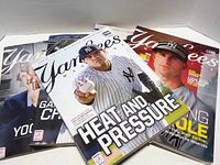 Stack of five Yankees magazines lying flat with visible front covers showing players and headlines.