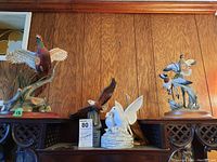 Full group shot of five bird figurines on shelving including pheasant, ducks, eagle, and white dove music box