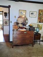 Frontal view of the three-drawer dresser with round mirror attached on top.