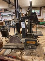 Front view of Busy Bee belt and disc sander showing the disc sanding wheel, belt sanding area, power motor, and sawdust coverage on the work surface.