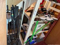 Full lot view showing golf clubs, shoes, hats on shelves in a basement